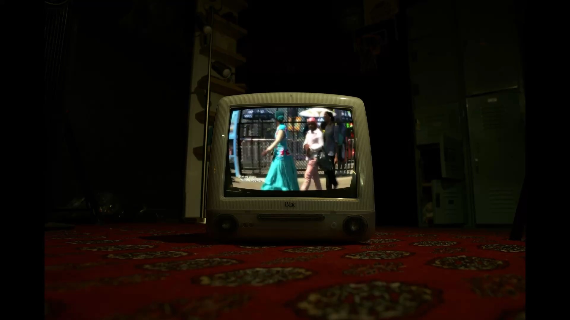 A vintage computer plays a film in a dimly lit room.
