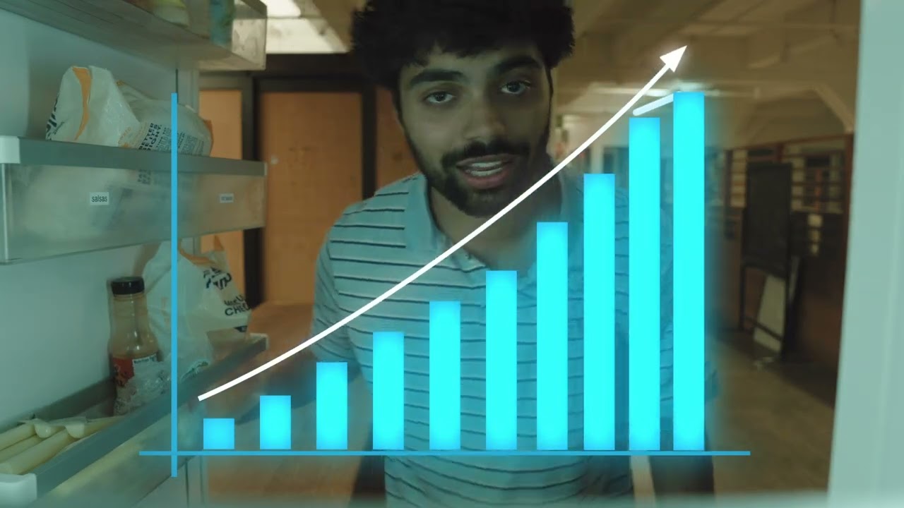 A man looks into a refrigerator behind a blue growth chart.